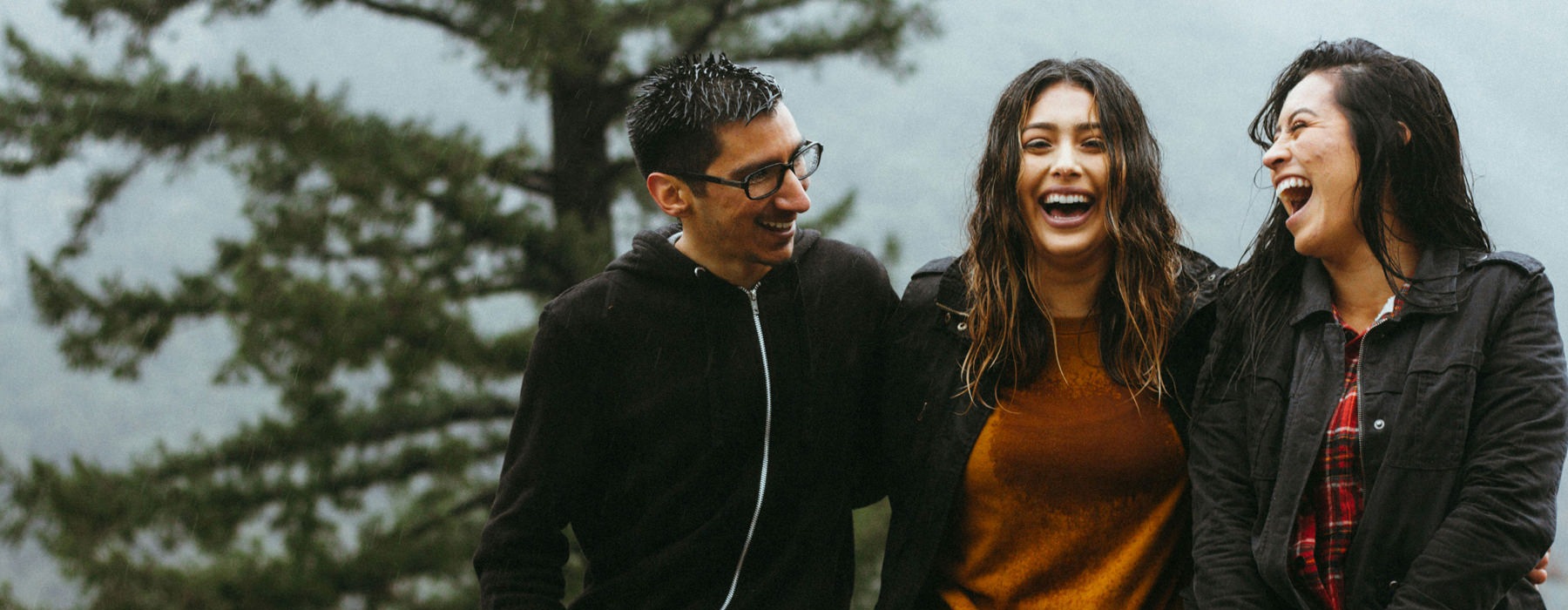 people sitting by a tree laughing